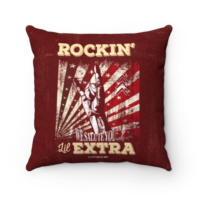 red pillow featuring design with a hand making the rock n' roll symbol and text 'Rockin' lil Extra' and 'We Salute You' for down syndrome awareness