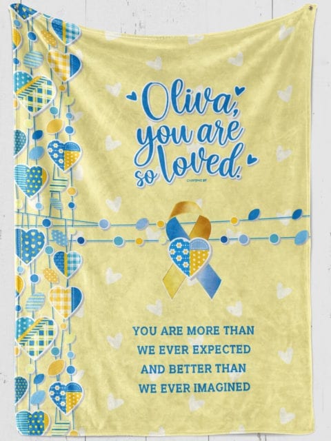 personalized down syndrome girl's blanket, yellow plush with blue hearts and down syndrome awareness ribbon and blue text '[girl's name] you are so loved, you are more than we ever expected and better than we ever imagined'
