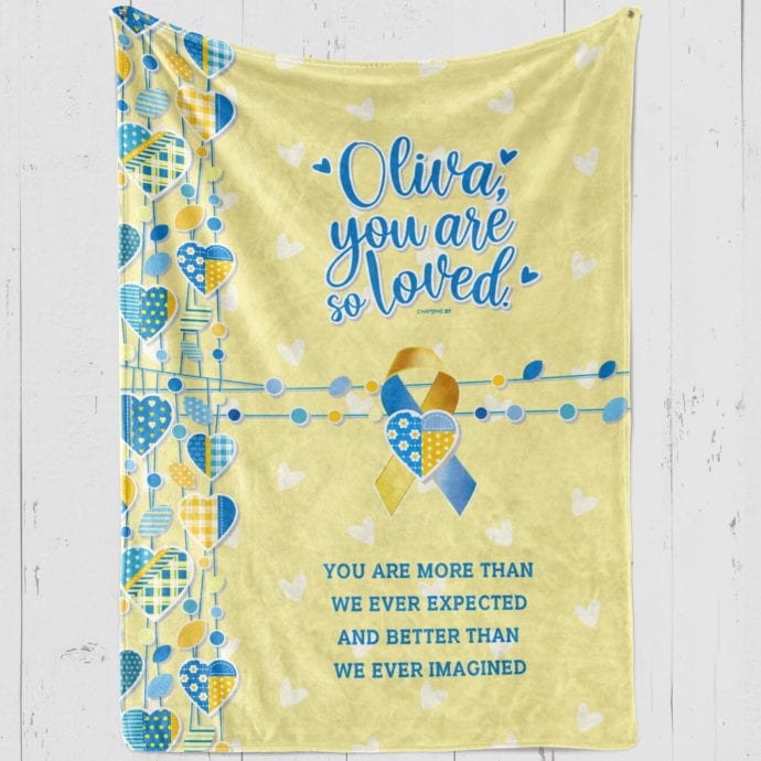 personalized down syndrome girl's blanket, yellow plush with blue hearts and down syndrome awareness ribbon and blue text '[girl's name] you are so loved, you are more than we ever expected and better than we ever imagined'