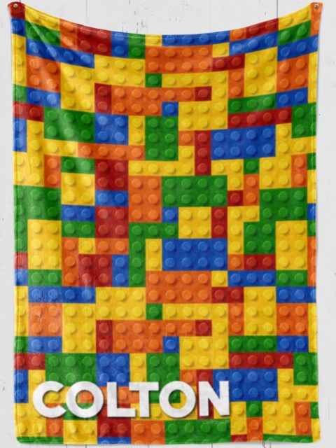 Personalized blanket with lego toys with green, yellow, red, blue lego blocks and white text personalized [name]